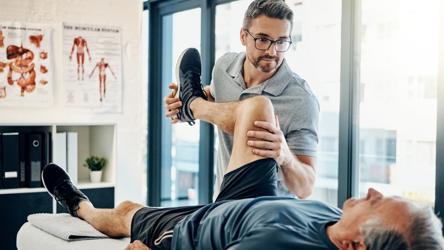 Man helps elderly man with rehab